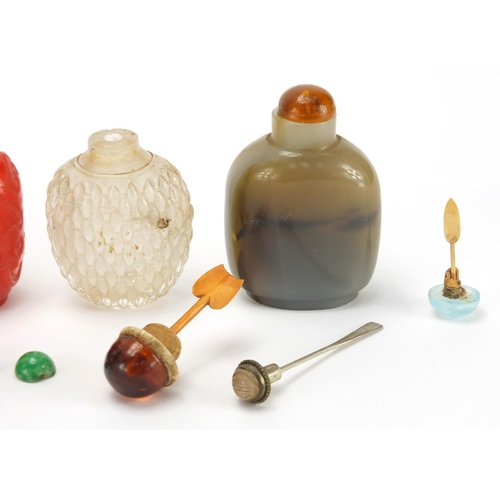 689 - Seven Chinese hardstone and glass snuff bottles together with a group of stoppers, including reverse... 