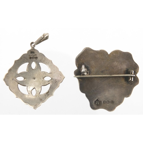 1041 - Two Art Nouveau silver brooches including an enamelled flower head example, both with indistinct mak... 