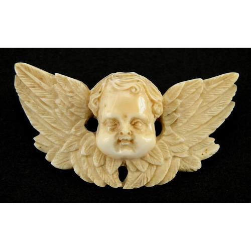 1074 - Well detailed Victorian carved ivory cherub pendant and similar earrings, the pendant 6.5cm wide, ap... 