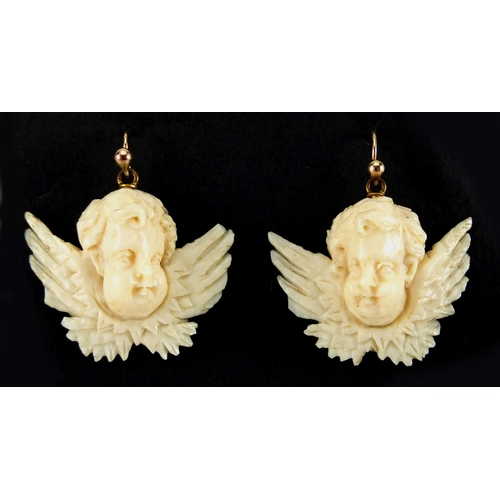 1074 - Well detailed Victorian carved ivory cherub pendant and similar earrings, the pendant 6.5cm wide, ap... 