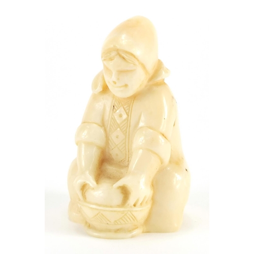 55 - Dieppe carved ivory figure of a young girl washing, incised numbers to the base, 6.5cm high