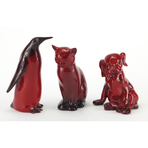 963 - Three Royal Doulton Flambe animals comprising a cat, penguin and puppy, factory marks to the bases, ... 