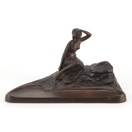 1011 - Art Nouveau patinated bronze desk inkwell with pen tray, modelled with a semi nude maiden, 23cm wide