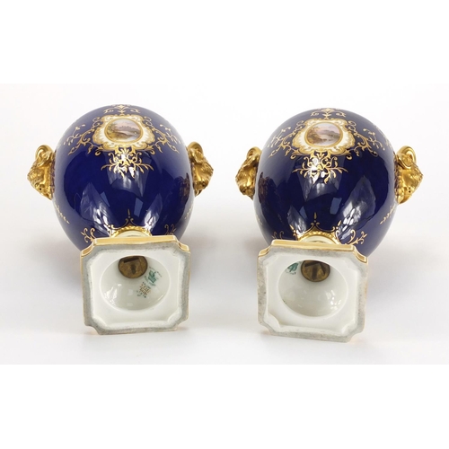 830 - Pair of Coalport vases and covers with twin rams head handles, each hand painted with panels of land... 