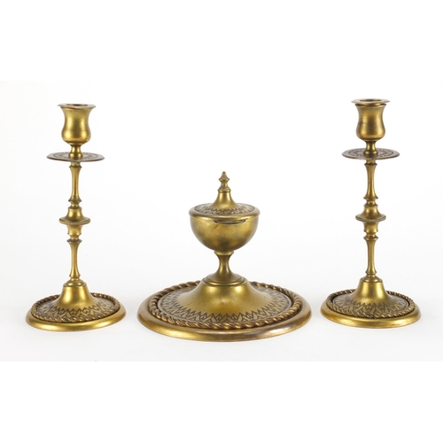 92 - 19th century gilt brass desk set comprising an inkwell and pair of candlesticks, each with chased de... 