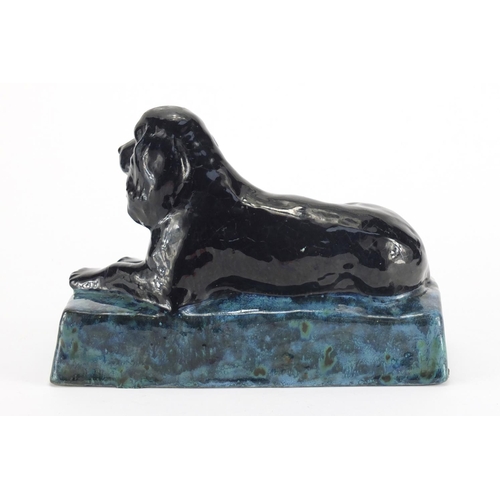 944 - Stella Crofts pottery model of a recumbent spaniel, with a black and mottled blue glaze, incised Ste... 