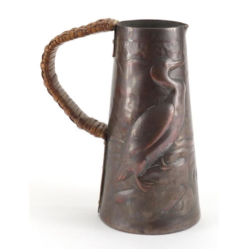 1032 - Arts & Crafts Newlyn School copper jug, the tapering body embossed with two birds, 15cm high