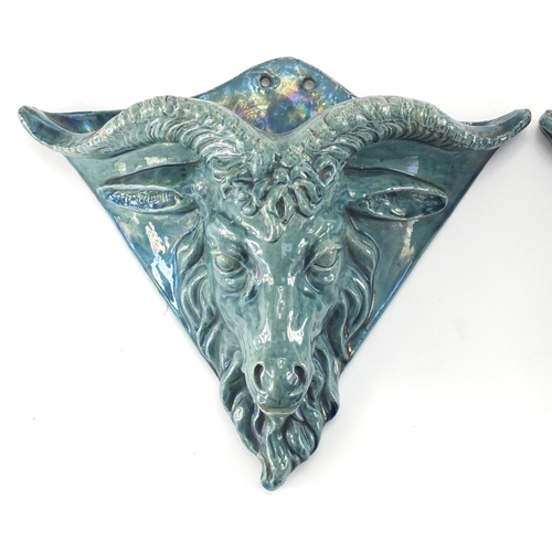 981 - Pair of blue glazed rams head design pottery wall pockets of triangular form, 26cm H x 31cm W