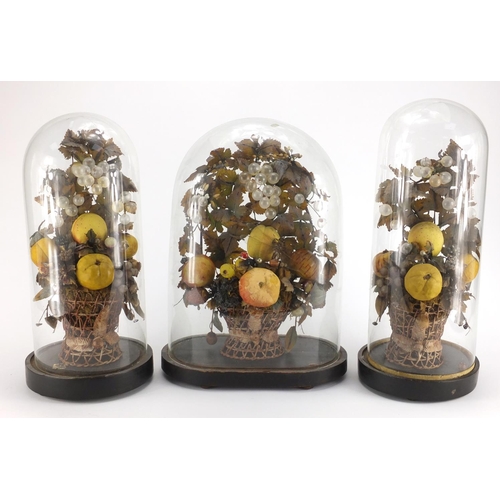 109 - Three Victorian wax fruit displays, each housed under glass domes raised on ebonised wood stands, th... 