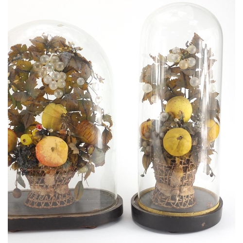 109 - Three Victorian wax fruit displays, each housed under glass domes raised on ebonised wood stands, th... 