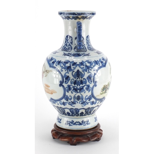 540 - Chinese blue and white porcelain vase, with twin handles raised on hardwood stand, the two central p... 