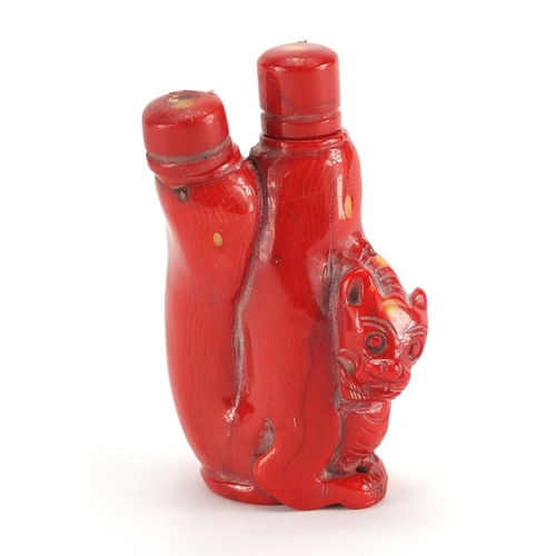 694 - Chinese carved coral double lion snuff bottle with stoppers, 10cm high