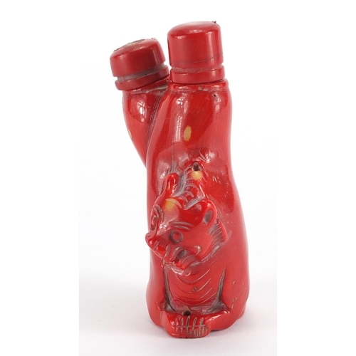 694 - Chinese carved coral double lion snuff bottle with stoppers, 10cm high