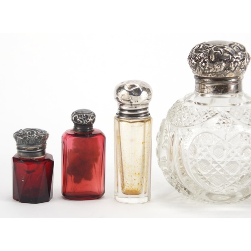 9 - Six silver mounted scent bottles including a globular cut glass example and two faceted ruby example... 