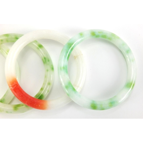 698 - Four Chinese white, green and red jade bangles, the largest approximately 8cm in diameter, approxima... 