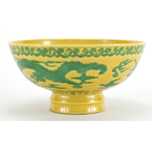 630 - Chinese porcelain yellow ground footed bowl, hand painted with two dragons chasing the flaming pearl... 