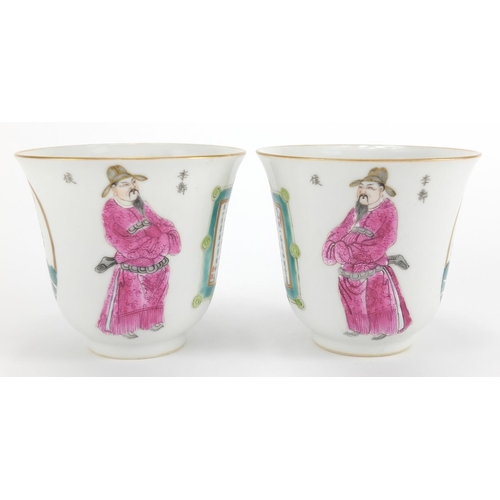 563 - Pair of Chinese porcelain fluted tea cups, each hand painted in the famille rose palette with warrio... 