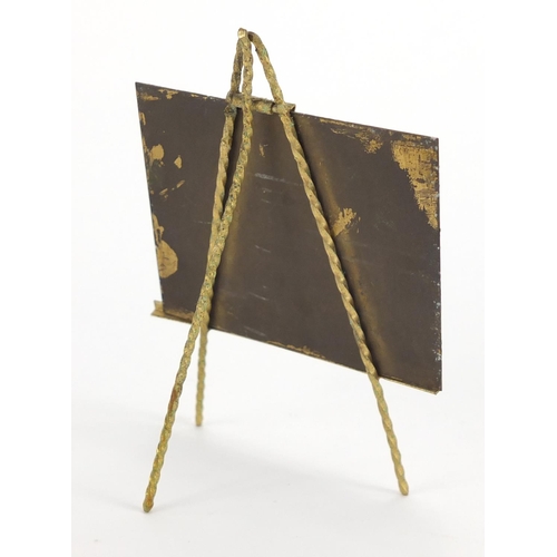 47 - Novelty brass easel housing a brass panel hand painted with Hampton Court Palace, overall 10.5cm hig... 