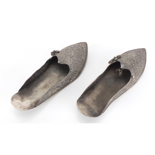 744 - Pair of Middle Eastern unmarked silver slippers, embossed with foliate motifs, each 17cm in length, ... 