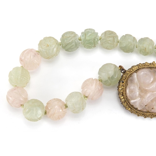 702 - Chinese rose quartz and green hard stone pendant on bead necklace, the pendant set in an unmarked gi... 