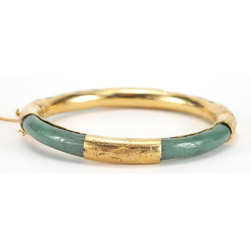 700 - Chinese green jade bangle with gold coloured metal mounts, 7.8cm in diameter, approximate weight 24.... 