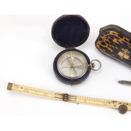 34 - Antique objects comprising a pocket compass with leather case, folding ivory rule, silver bladed mot... 