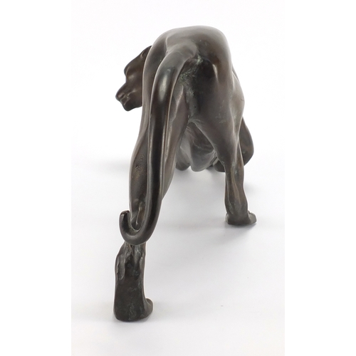 1018 - Modernist patinated bronze study of a crouching leopard, 53cm in length