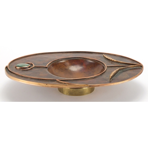 1035 - Sam Fanaroff oval copper and brass dish having an applied flower design, set with a green cabochon, ... 