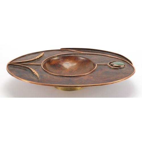 1035 - Sam Fanaroff oval copper and brass dish having an applied flower design, set with a green cabochon, ... 