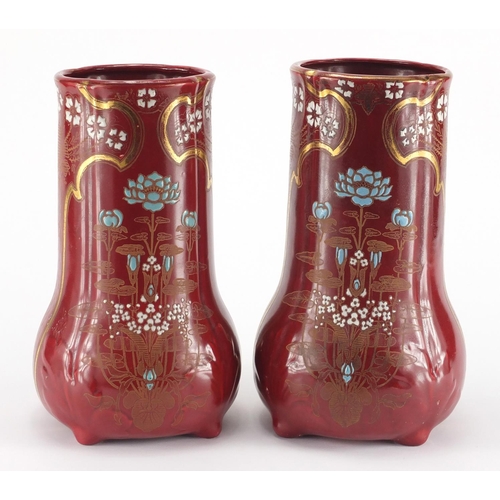 1001 - Pair of Art Nouveau pottery four footed vases, each enamelled and gilded with stylised flowers, fact... 