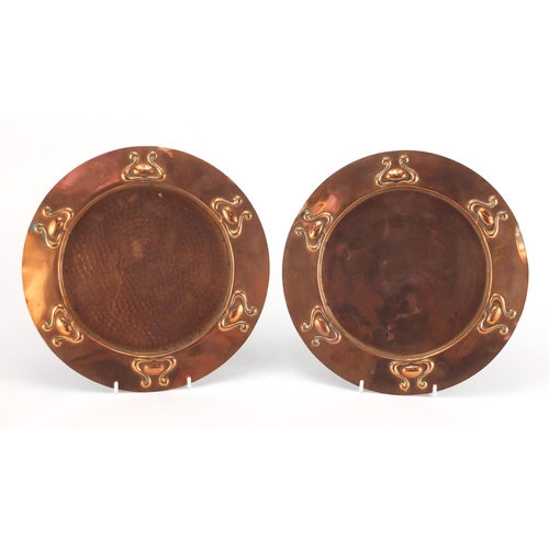 1033 - Near pair of Arts & Crafts embossed copper dishes, in the style of Keswick, one with planished decor... 