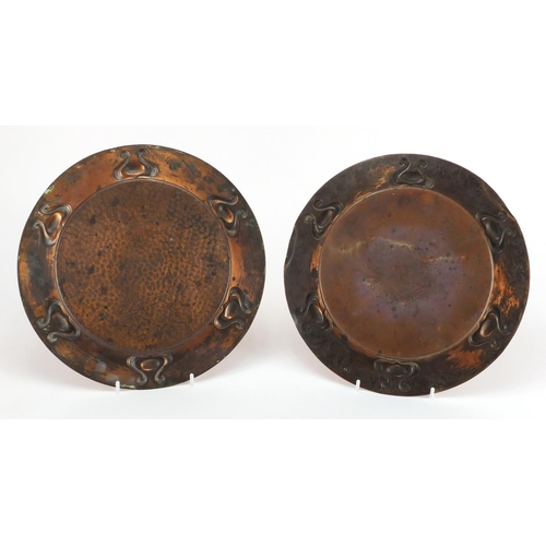 1033 - Near pair of Arts & Crafts embossed copper dishes, in the style of Keswick, one with planished decor... 