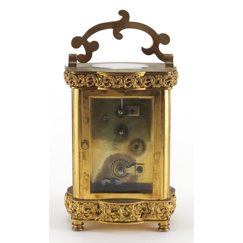 1273 - Gilt brass carriage clock with foliate blind fret panel, the enamelled chapter ring with Arabic nume... 