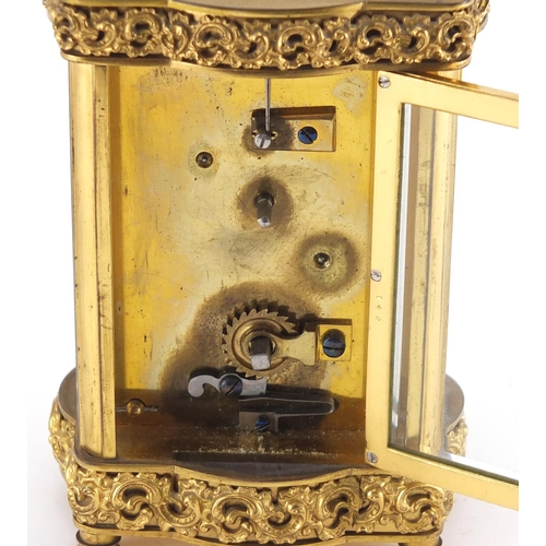 1273 - Gilt brass carriage clock with foliate blind fret panel, the enamelled chapter ring with Arabic nume... 