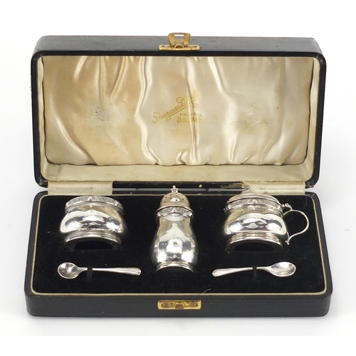 207 - Silver three piece cruet with blue glass liners by Adie Brothers Ltd, Birmingham 1936, housed in a S... 