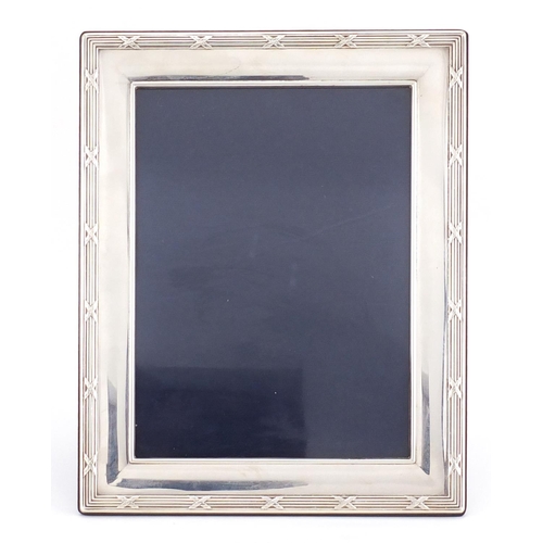 185 - Rectangular silver easel photo frame, with stylised border, by Carrs, 26cm x 21cm