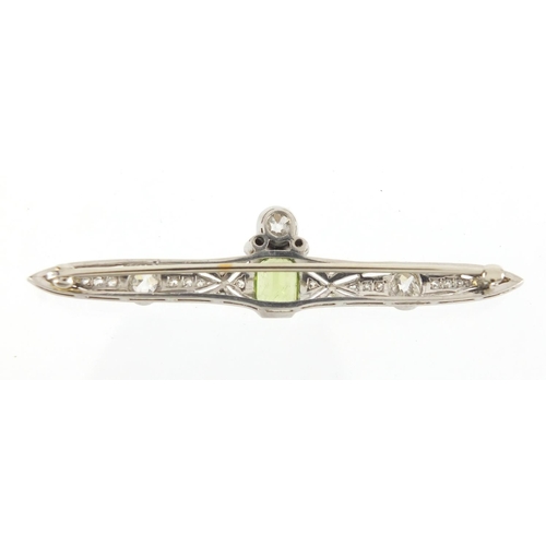 1043 - Art Deco unmarked white metal diamond and green stone bar brooch, housed in a Kendal & Dent velvet l... 