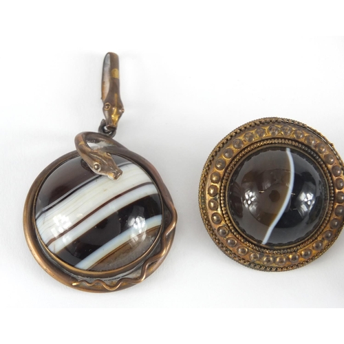 1064 - Three Victorian Scottish agate and gilt metal mourning pendants and brooches, one with serpent mount... 