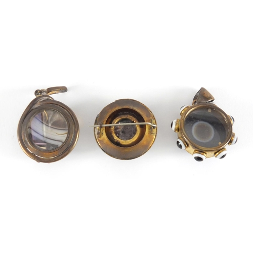 1064 - Three Victorian Scottish agate and gilt metal mourning pendants and brooches, one with serpent mount... 