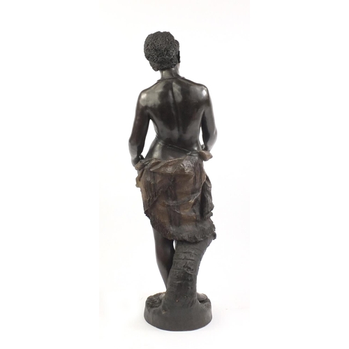 107 - 19th century floor standing terracotta figure of a semi nude African female holding a basket, in the... 