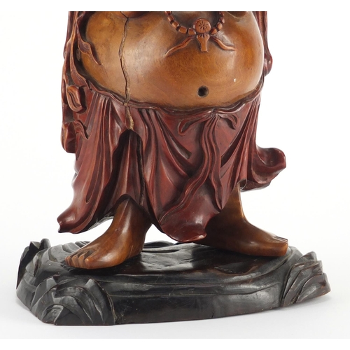 2181 - Chinese hardwood carving of Happy Buddha holding a lotus flower aloft, 39.5cm high