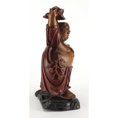 2181 - Chinese hardwood carving of Happy Buddha holding a lotus flower aloft, 39.5cm high