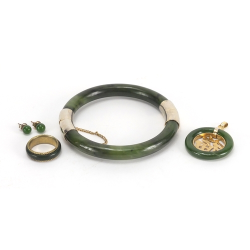 701 - Chinese spinach green jade jewellery suite comprising a bangle, pendant, pair of earrings and ring, ... 