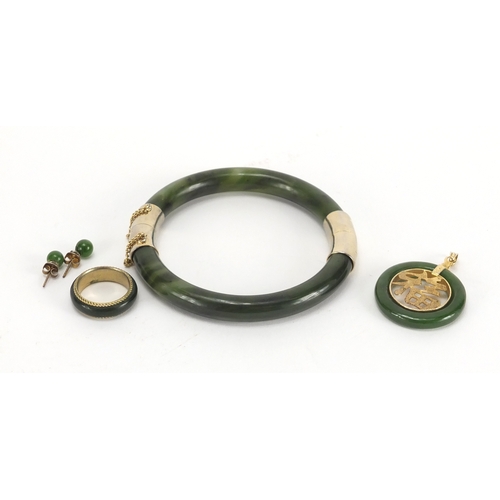 701 - Chinese spinach green jade jewellery suite comprising a bangle, pendant, pair of earrings and ring, ... 