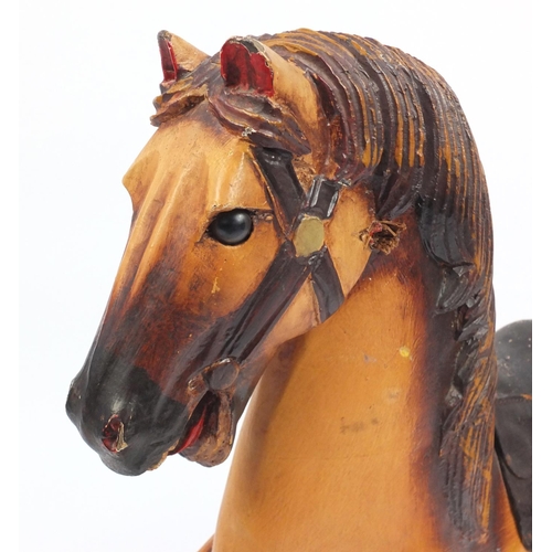 2122 - 19th century French carved wood and painted pull along horse with metal wheels, 78cm high