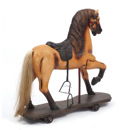 2122 - 19th century French carved wood and painted pull along horse with metal wheels, 78cm high