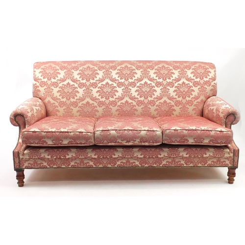 2008 - Pink floral upholstered three seater settee and two matching armchairs, the settee 180cm wide