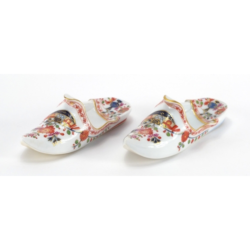 2218 - Pair of Meissen porcelain slippers, each hand painted and gilded with flowers, cross sword marks to ... 