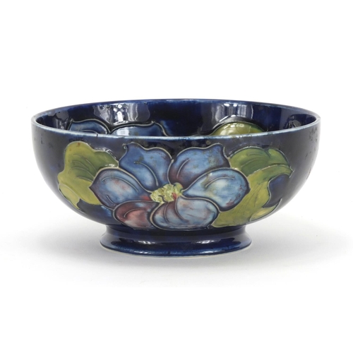 2130 - Moorcroft pottery footed bowl, hand painted and tube lined with flower heads, paper labels to the ba... 