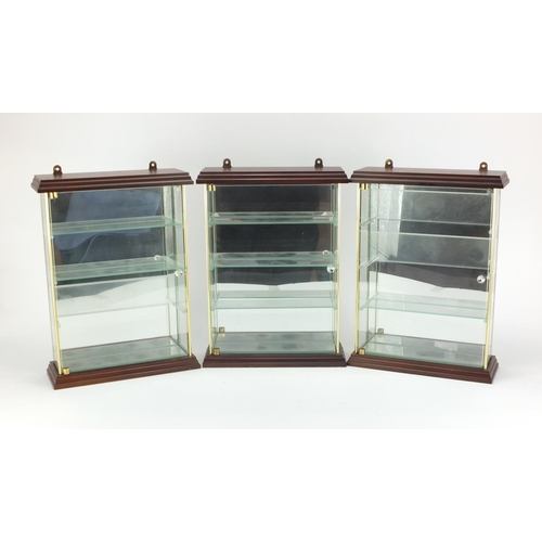 2247 - Three glazed mahogany wall hanging display cases, with mirrored backs, each 33cm H x 24.5cm W x 9cm ... 